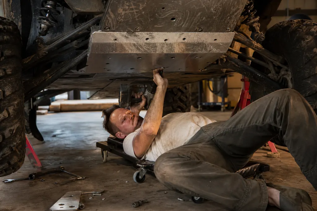Un mécanicien fixe un sabot de protection en aluminium sous un SSV