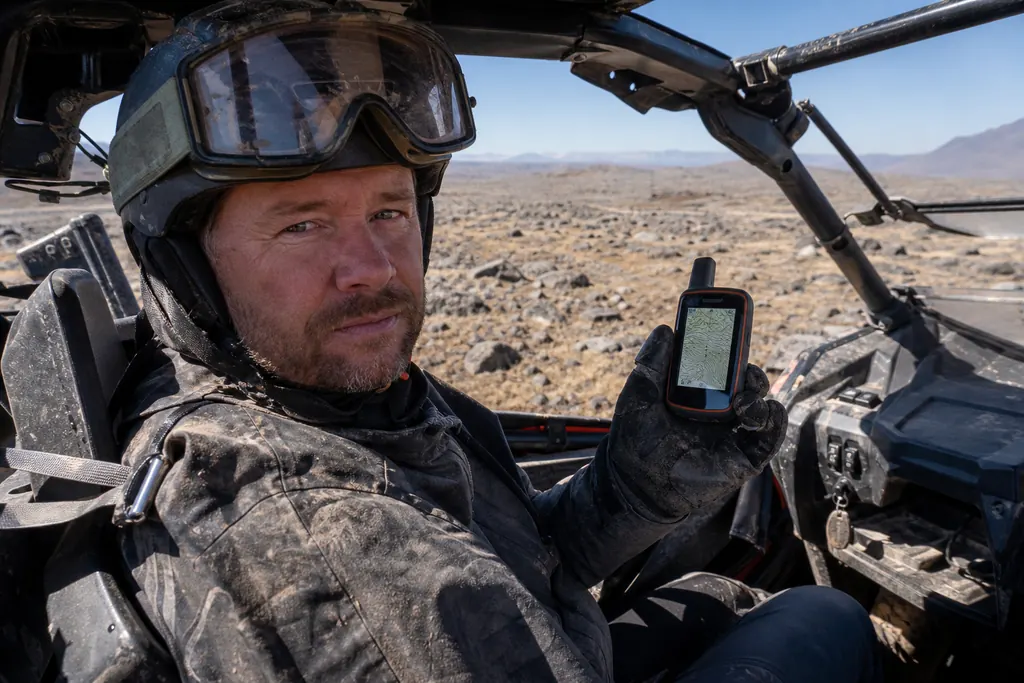 Un pilote consulte un GPS de randonnée assis dans son SSV sur un plateau