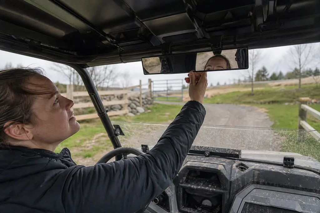 Une conductrice règle le rétroviseur central panoramique de son SSV