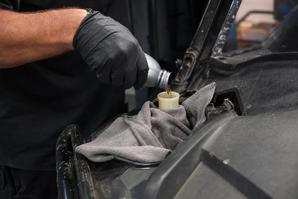 Appoint de liquide de frein dans le réservoir d'un SSV, chiffon de protection autour