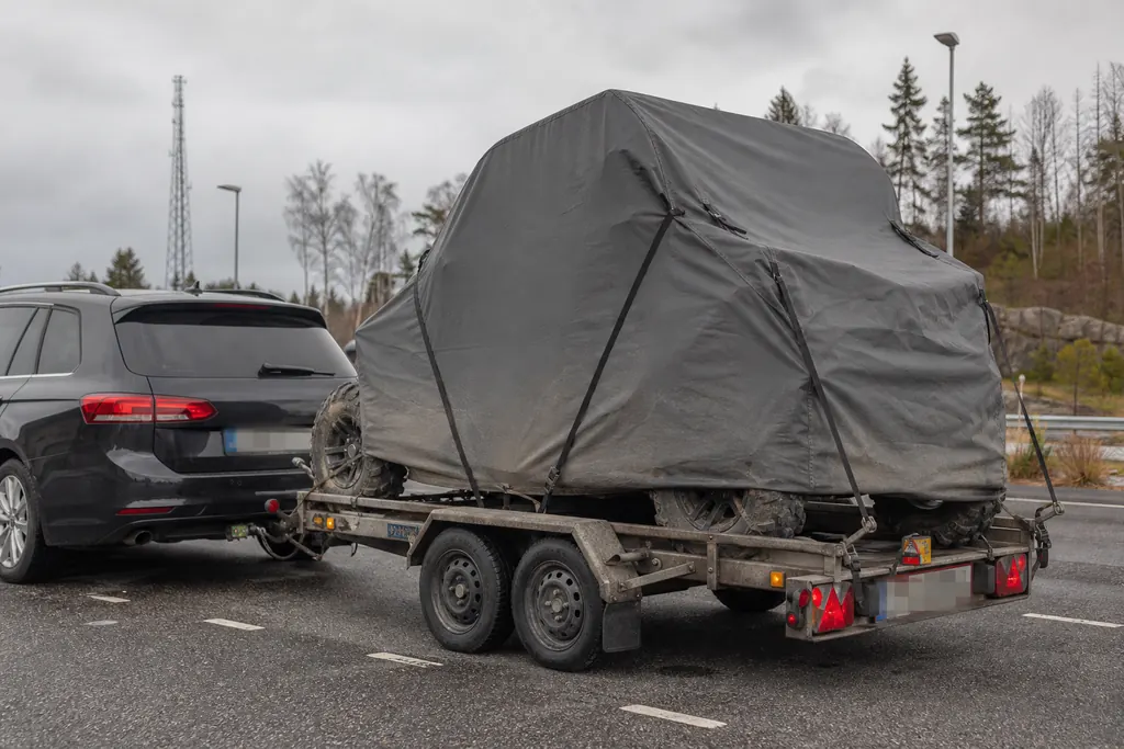 SSV sous housse de transport ajustée, chargé sur une remorque à une aire de repos