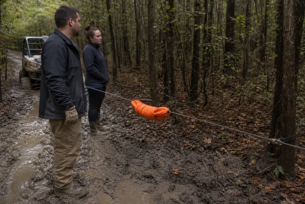 Amortisseur orange posé sur une ligne de treuil tendue entre un SSV embourbé et un arbre